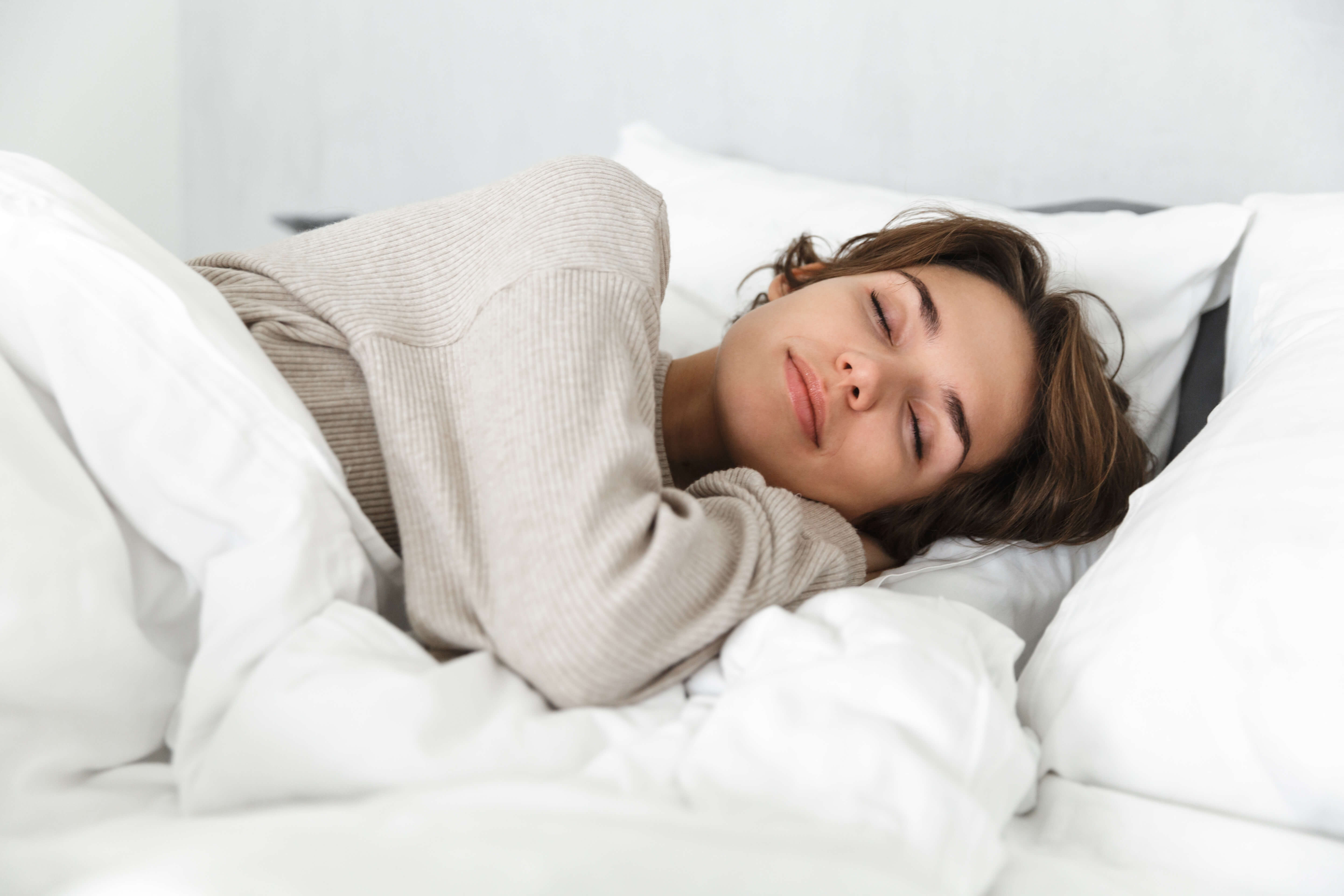 Illustration d'une personne détendue dans un lit avec un graphique de qualité de sommeil en arrière-plan