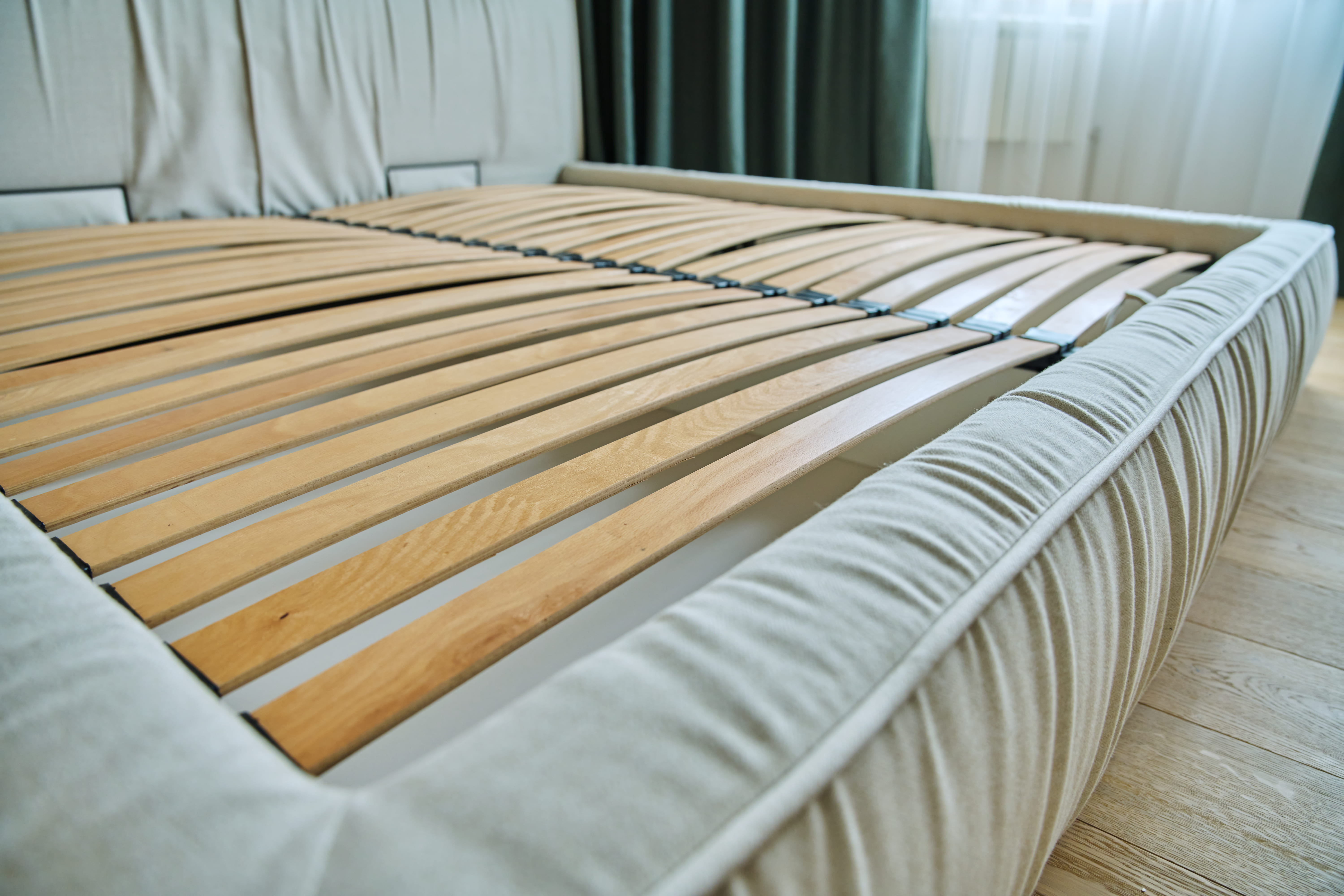 Sommier à lattes en bois sans matelas dans une chambre épurée