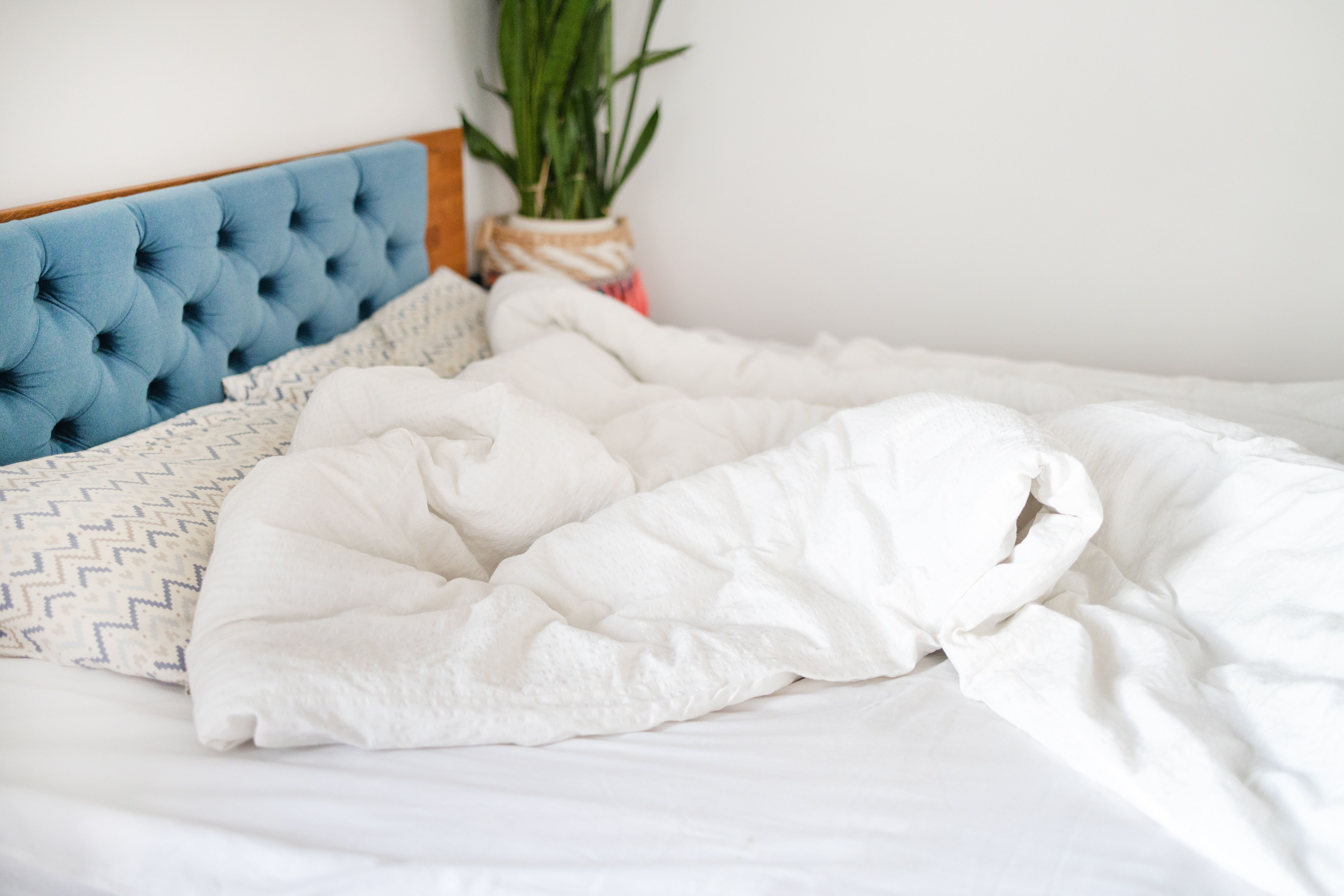 Couette en duvet naturel gonflante sur un lit, synonyme de confort haut de gamme